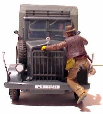 Indiana Jones hangs onto the desert convoy truck